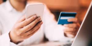 Female hand holding smartphone and credit card